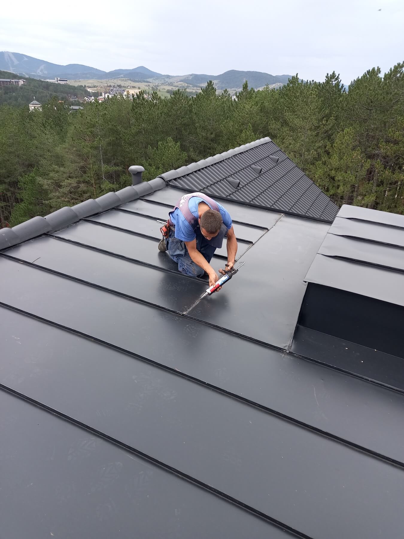 Radnik popravlja krov zgrade